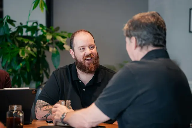 Zwei Männer sprechen in einem Café gut gelaunt miteinander